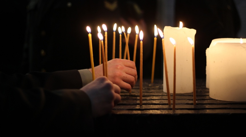 Руки що ставлять запалені свічки